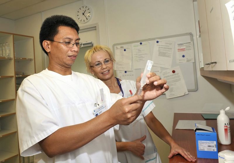 Photograph of a Filipino nurse measuring pharmaceuticals in a Finnish hospital.