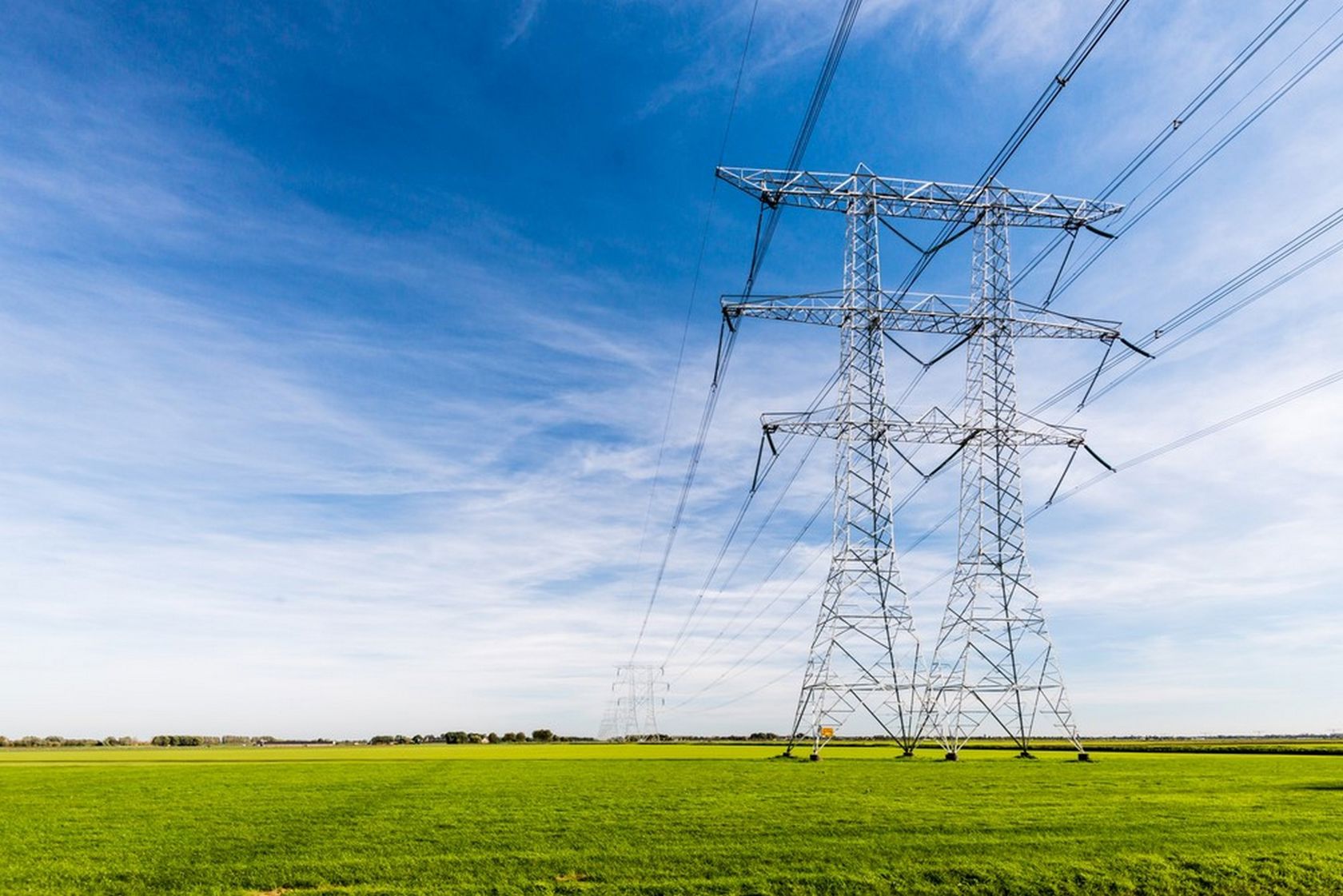 Photograph of high-tension power lines in a field.