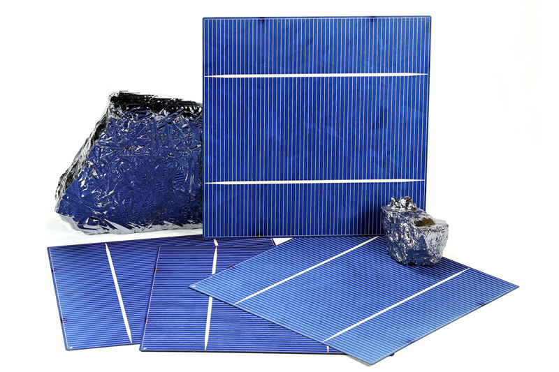 Photograph of solar cells and polycrystalline silicon on white background.