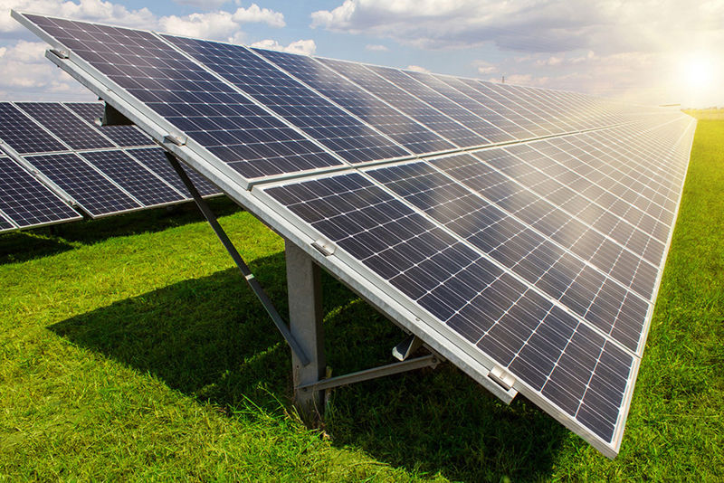 A photograph of solar panels on a green field.
